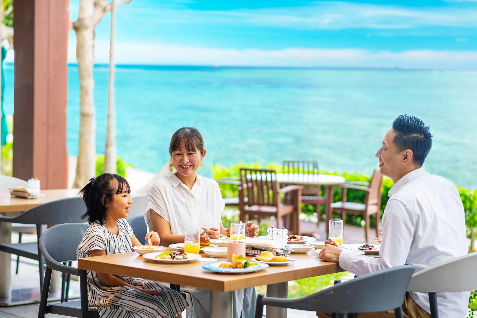 海辺のレストランで食事を楽しむ家族