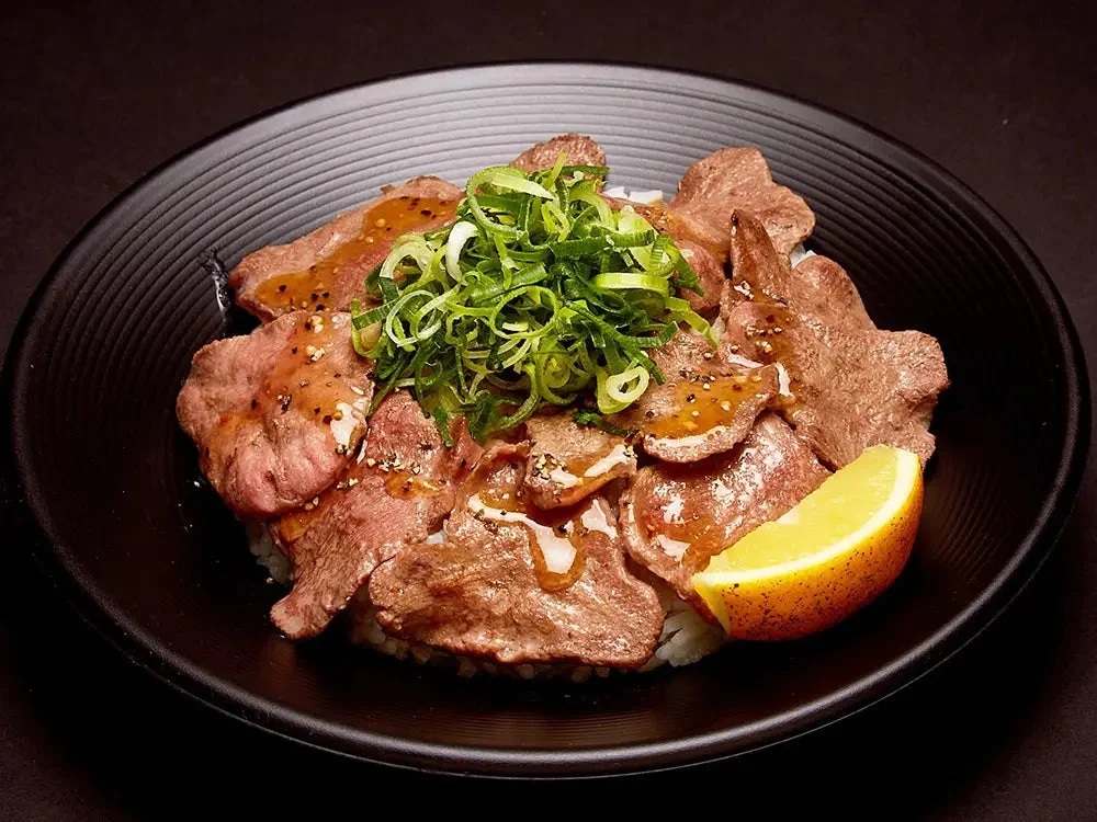 ネギとレモンが添えられた牛タン丼