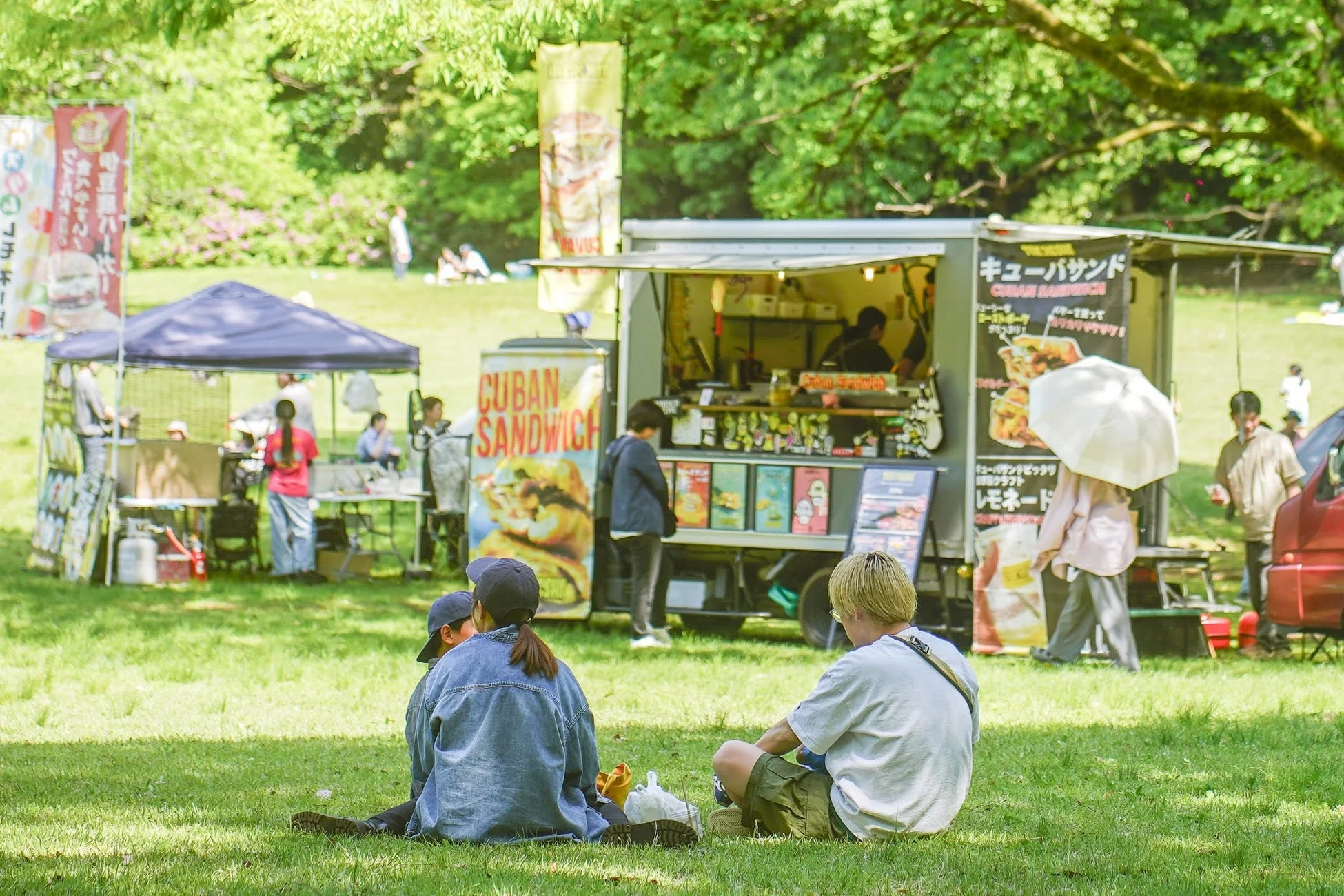 フードトラックと芝生でくつろぐ人々