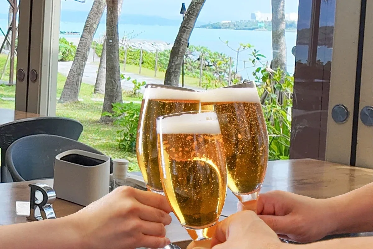 海辺でビールを乾杯する様子